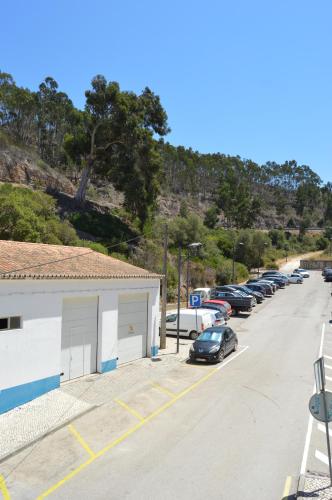 a street with cars parked in a parking lot at Paragem dos Pacatos - Odeceixe in Odeceixe