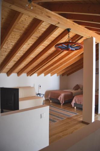 a living room with a vaulted ceiling with wooden beams at Paragem dos Pacatos - Odeceixe in Odeceixe