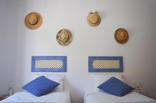 two beds in a room with hats on the wall at Vita Portucale ! Paragem dos Pacatos - Odeceixe in Odeceixe
