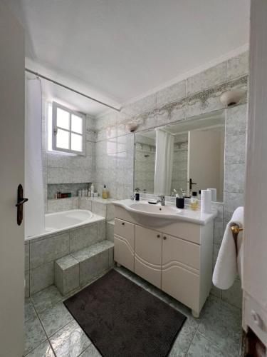 y baño con lavabo, bañera y espejo. en KATINA'S DREAM HOUSE IN PELOPONNESE, en Egio
