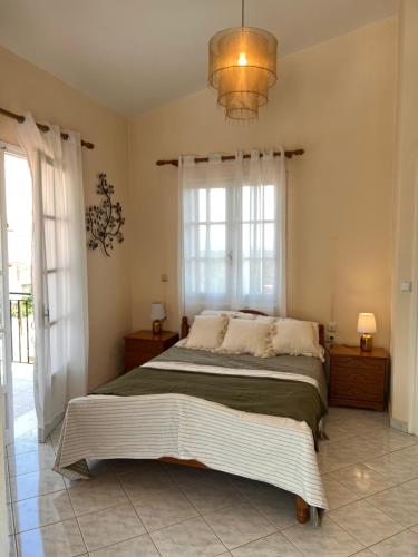a bedroom with a large bed and a chandelier at KATINA'S DREAM HOUSE IN PELOPONNESE in Aigio
