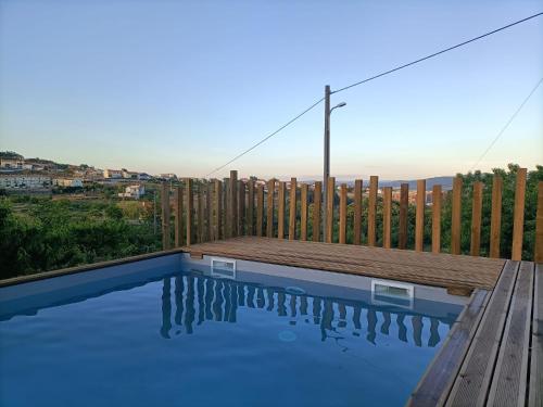 a swimming pool with a deck and a wooden fence at Quinta da Feteira - Conforto, Aventura, Saúde in Maiorais