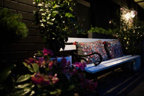 a bench with two pillows on it next to some flowers at Fregata in Ustka
