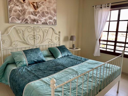 a bedroom with a white bed with blue pillows at Balcon del Mar A&V Ocen View Costa del Silencio in Costa Del Silencio