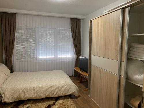 Dormitorio pequeño con cama y TV en Anja Apartman, en Bosanski Šamac