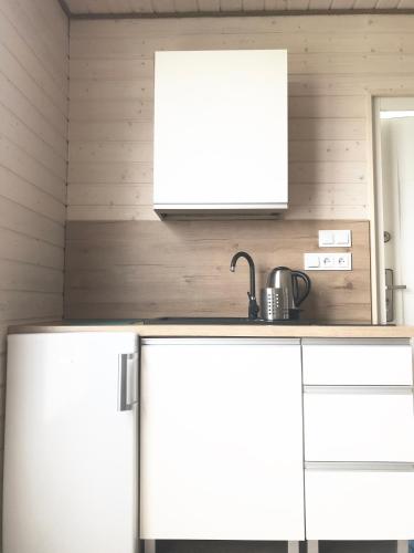 a kitchen with two white refrigerators and a sink at BALTICO Domki Letniskowe in Sarbinowo