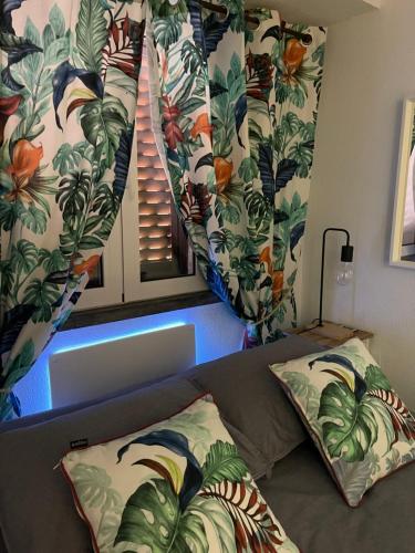 Seixal Bay House!! في سيكسال: غرفة نوم مع سرير ونافذة مع اوراق الشجر