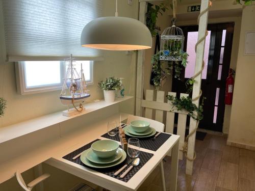 una cocina con una mesa con platos verdes. en Seixal Bay House!!, en Seixal