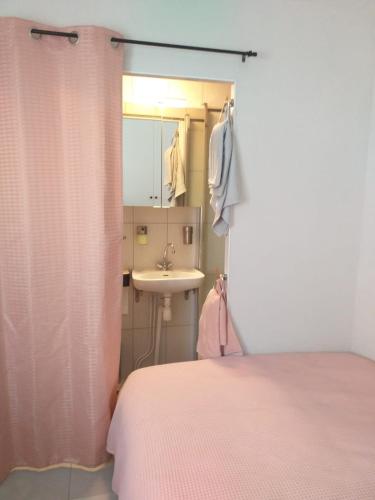 une chambre avec un lit, un lavabo et un miroir dans l'établissement L'îlot à la Baule Homey Home's, à La Baule