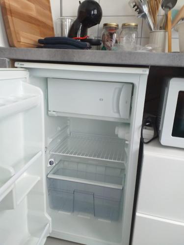 un réfrigérateur vide avec sa porte ouverte dans une cuisine dans l'établissement L'îlot à la Baule Homey Home's, à La Baule