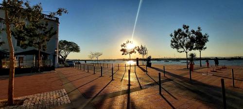 a street with trees and the sun in the sky at Seixal Bay House!! in Seixal