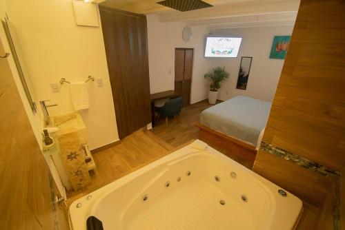 a bathroom with a bed and a tub in a room at El Jardín de la Abuela in Querétaro