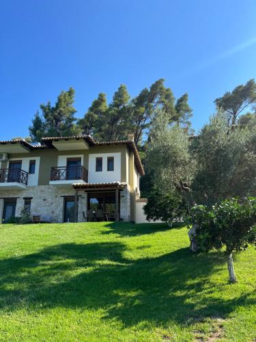 a house with a large yard with trees at Paralia Homes peaceful 2 bedroom, unit # 2 in Kriopigi