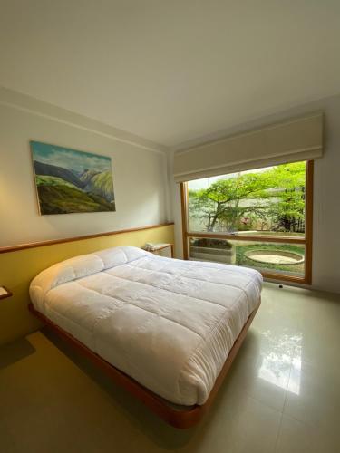 a bedroom with a large bed and a large window at Casa Tramontana in Mérida