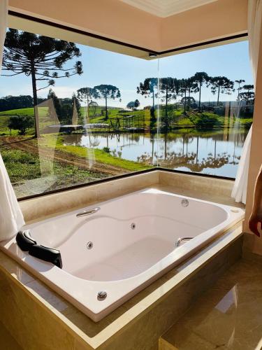 a bath tub in a room with a large window at Hope Valley Adventure Resort in Guarapuava