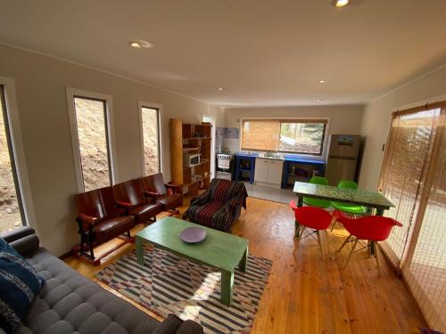 a living room with a couch and a table and chairs at Cabaña Girasol - Cocina Parking Piscina Wifi in Algarrobito