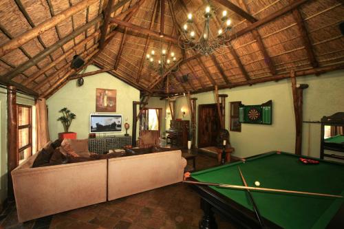 a living room with a couch and a pool table at Summer Garden Guest House (The Palms) in Benoni