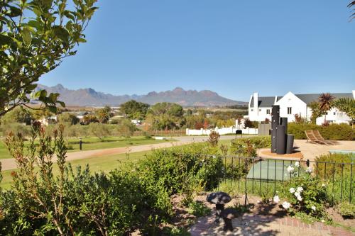a view of a garden with a house in the background at Wild Mushroom Country House in Stellenbosch