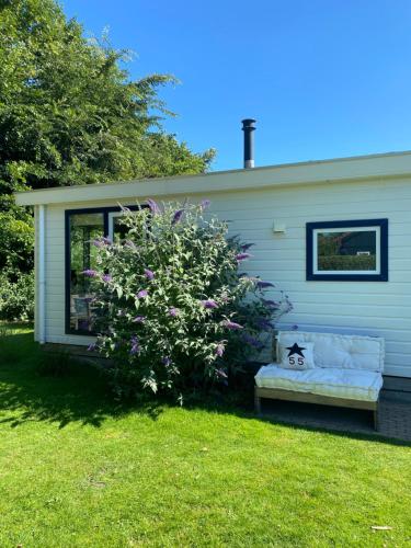 a couch on the side of a house with a bush at Chalet ZWIN & ZEE Cadzand-Retranchement in Retranchement