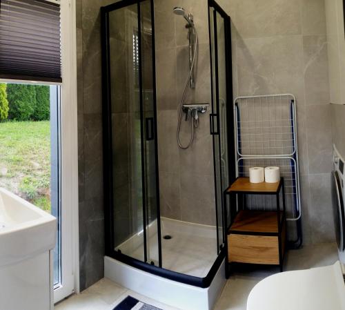 a shower with a glass door in a bathroom at Rospuda A 
