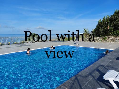 a pool with a view with people in the water at Hendre Coed Isaf Caravan Park in Barmouth