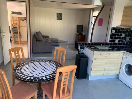 une cuisine et une salle à manger avec une table et des chaises dans l'établissement Magnifique bas de villa deux chambres situé prés des plages et du golf, à Saint-Briac-sur-Mer