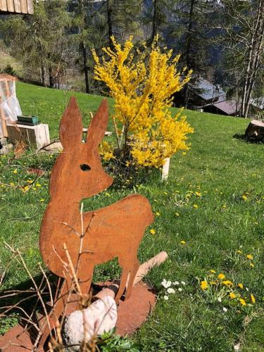 a wooden figure of a rabbit sitting in the grass at Appartamento Giada Pozzale di Pieve di Cadore(BL) in Pieve di Cadore