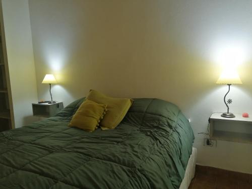 a bed with two yellow pillows on it in a room at Departamento Los Inmigrantes in Esquel