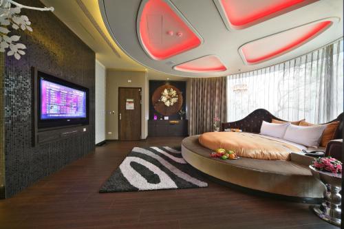a bedroom with a large bed and a flat screen tv at Han Guan Motel in Taichung