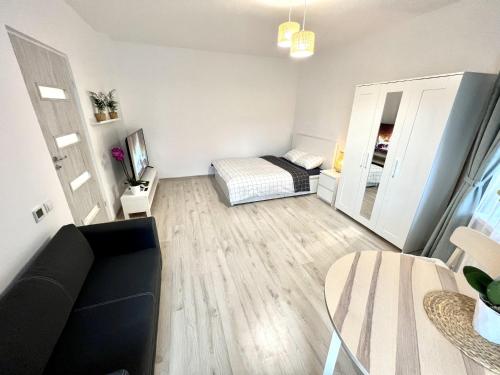 a living room with a couch and a bed and a mirror at New York Apartments in Katowice