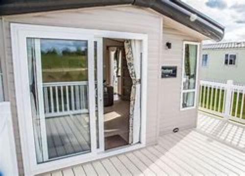 a white house with a large sliding glass door at Roxbury 5 Star 6 berth Luxury Caravan in Exeter