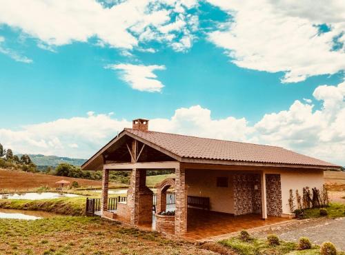 グアラプアバにあるHope Valley Adventure Resortの青い空が広がる野原にある建物