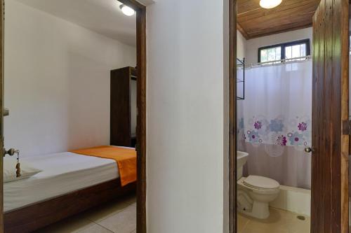 ein Schlafzimmer mit einem Bett, einem WC und einer Dusche in der Unterkunft Villa Bayacanes con piscinas privadas in Jarabacoa