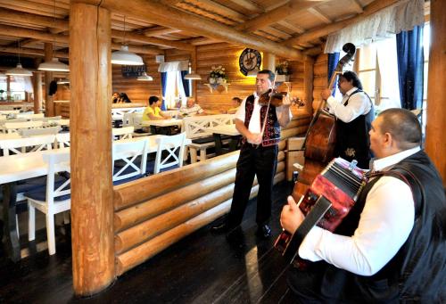 a group of men playing music in a restaurant at APLEND Koliba Kamzík in Smokovce