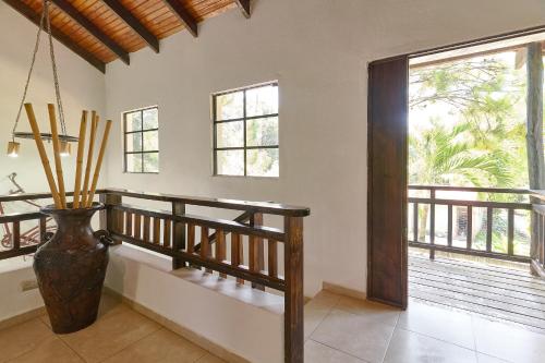 a hallway with a vase and a staircase with a window at Villa Bayacanes con piscinas privadas in Jarabacoa