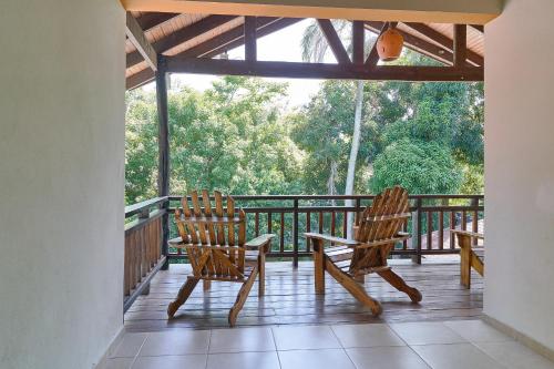 two chairs sitting on the deck of a house at Villa Bayacanes con piscinas privadas in Jarabacoa