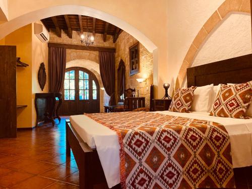 ein Schlafzimmer mit einem großen Bett in einem Zimmer in der Unterkunft S.Nikolis' Historic Boutique Hotel in Rhodos (Stadt)