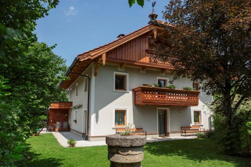 Casa blanca grande con techo de madera en Ferienwohnung Kastenmühle im Mondseeland, en Guggenberg