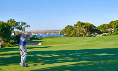 um homem a balançar um taco de golfe num campo de golfe em Quinta do Lago Golf, Sea & Sun na Quinta do Lago