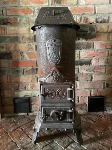an old stove sitting in front of a brick wall at Sepasaun in Joaveski
