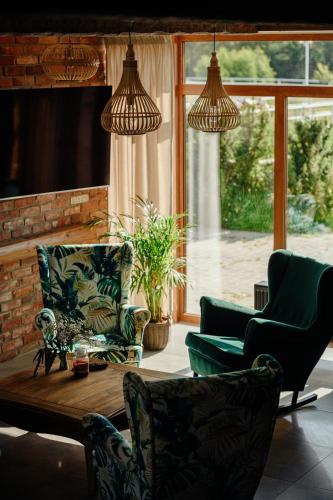 a living room with two chairs and a coffee table at Folwark Pod Dębem in Nowa Karczma