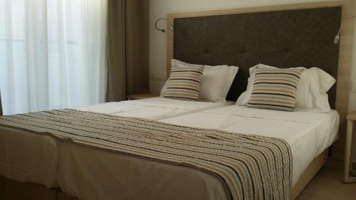 een slaapkamer met een groot bed met 2 kussens bij The Perfect Spot Apartments in Rhodos-stad