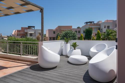 a group of white chairs sitting on a balcony at Afroditi Suite in Loutra