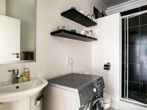 a bathroom with a washing machine and a sink at Splice Apartments in Johannesburg