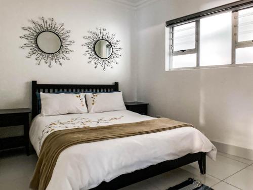 1 dormitorio con 1 cama con 2 espejos en la pared en Splice Apartments, en Johannesburgo