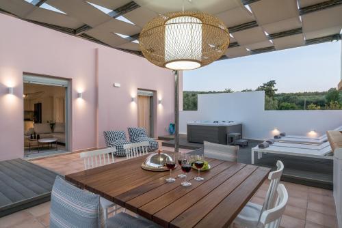 a dining room and living room with a wooden table and chairs at Afroditi Suite in Loutra