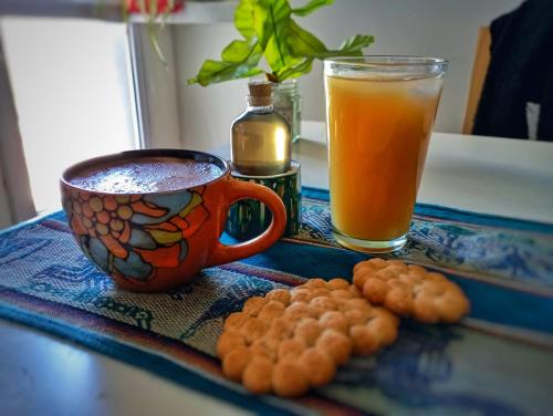 una mesa con una taza de café y un vaso de zumo de naranja en Departamento Albaluz Barrio Sur en San Miguel de Tucumán