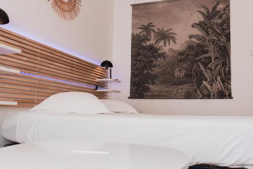 une chambre avec un lit blanc et un tableau au mur dans l'établissement R'Apparts T2 Au Grenoblois Dormant, à Grenoble