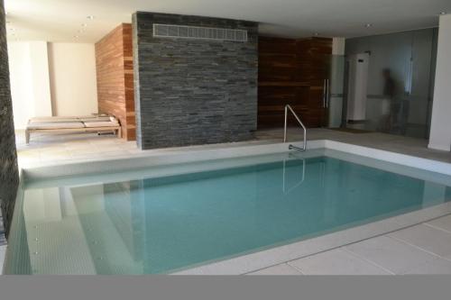uma piscina numa casa com uma parede de tijolos em Forest Tower 2 - Apartamento 305 em Punta del Este