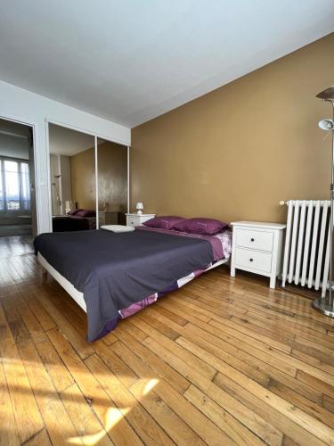 a bedroom with a large bed and a wooden floor at Amazing apartment 1BDR2PAX PARIS Boulogne Roland Garros in Boulogne-Billancourt